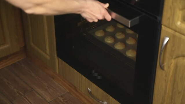 The girl puts the dough in the oven