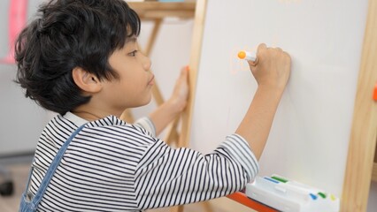 Asian little boy doing magnetic on whiteboard, magnetic whiteboard educational in...