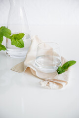 Glass cup containing natural water on white background. Minimalist image. Drinking water simplicity concept.