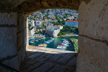 Viiewing point in the Old City Wall looks out at small boats and houses - obrazy, fototapety, plakaty