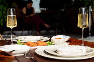 organized table of plates and glasses with champagnes with patties prepared for someone to sit down to eat