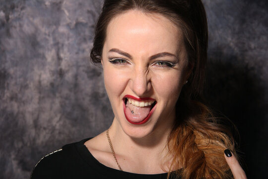Portrait of a beautiful fashion glamour girl brown-haired in the studio with pirsing