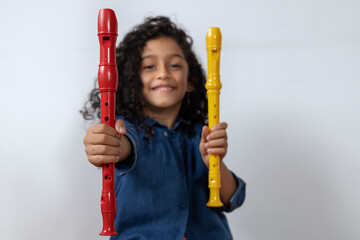 Latin American girl smiling and happy holding and showing two soprano recorders © Amilciar