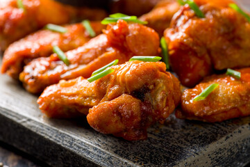 Buffalo chicken wings with green onion on the board extreme macro close up