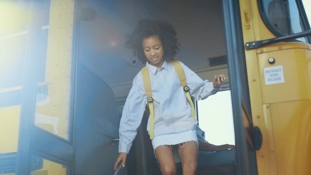 Diverse pupils leaving schoolbus. Happy children jump out academic shuttle.