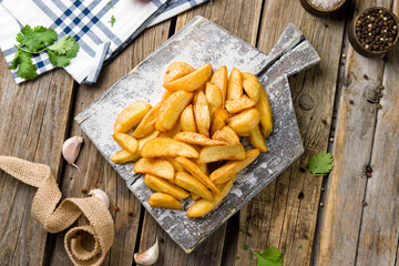 The potatoes wedges on the Board top view on wooden table