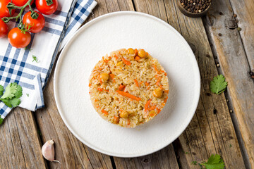 Rice with vegetables and nuts top view on wooden table