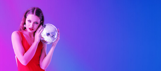 Fashionable young woman holding disco ball on color background with space for text