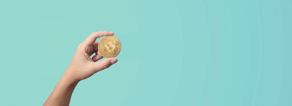 man holding a bitcoin in his hands on blue background