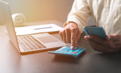 Fototapeta premium Young businessman using a calculator on the table,