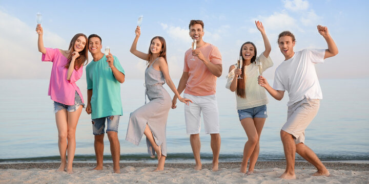 Happy Friends Drinking Champagne On Sea Beach