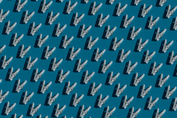 Fototapeta premium Pattern of white clothespin on blue background, plastic clothes peg for holding clothes to clothesline
