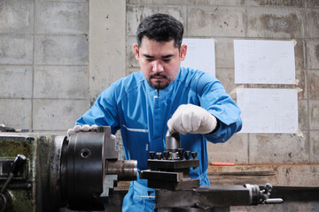 One professional Asian male industry engineer worker works in a safety uniform with metalwork...