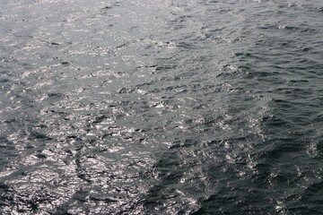 Smooth surface of far open Baltic sea. Deep blue water, reflections of sun light. Photo taken from ship