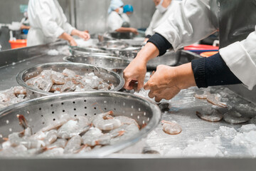 Latin American workers inspecting frozen farmed shrimp at an industrial food plant in Chinandega...
