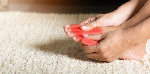 Foot pain, Asian woman holds her toe injury feeling pain her foot at home, female suffering from...