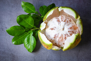 pomelo fruit on dark background, fresh green pomelo peeled on and green leaf frome pomelo tree ,...