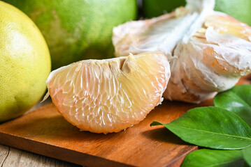 pomelo fruit on wooden background, fresh green pomelo peeled and leaf frome pomelo tree , pummelo ,...