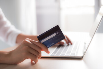 woman hand holding credit card and using laptop