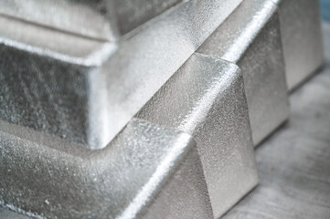 Stack of industrial silver ingots at bright light in storage