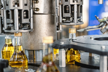 Automatic equipment puts caps on alcohol beverage bottles