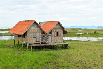Fototapeta na wymiar Abandoned house with orange roof located in Thale Noi area the part of Songkhla Lake, Phatthalung, THAILAND.