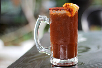 Micheladas served on an outdoor table, it is a Mexican alcoholic drink that is prepared by mixing...