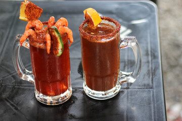 Micheladas served on an outdoor table, it is a Mexican alcoholic drink that is prepared by mixing...