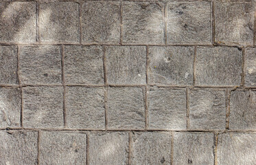 Granite cobblestoned pavement background. Stone pavement texture. Abstract background of cobblestone pavement close-up