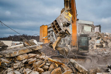 Excavator with hydraulic press breaks concrete leftovers