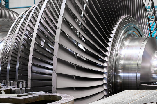 Rotor with blades of powerful steam turbine in workshop