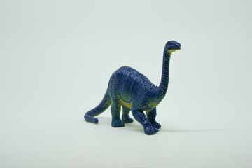 Side view of plastic brontosaurus dinosaur plastic toy for kids, isolated on a studio lighting background