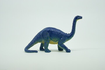 Side view of plastic brontosaurus dinosaur plastic toy for kids, isolated on a studio lighting...