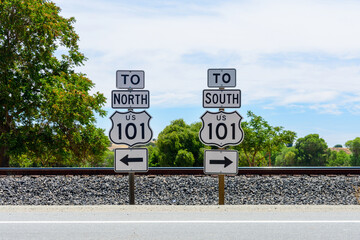 US Highway 101 directional signs. North and South freeway road signs. Background railroad tracks...