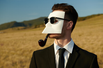 masked person smoking pipe