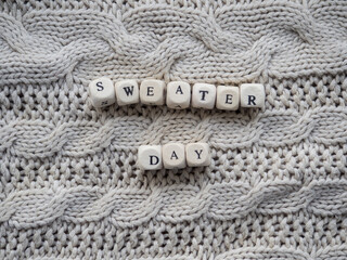 World sweater day. Beige background with text Sweater Day with place for your text. Copy space.