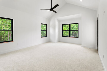 large empty room with black windows and natural finished hardwood flooring