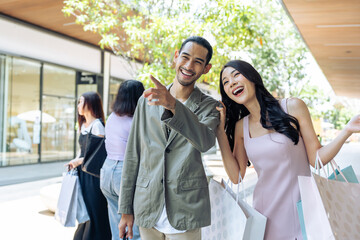 Asian young man and woman shopping goods outdoors in department store. 