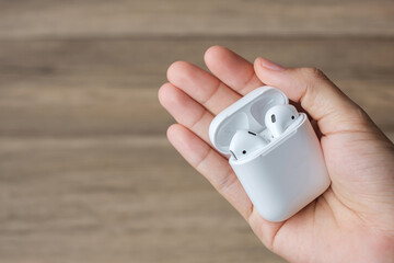 White wireless earphone or headphones on table for using with smartphone. Technology concept