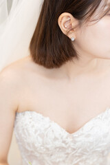 Beautiful young bride with a bob haircut wearing luxury earrings