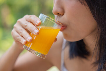 Close up of woman drink orange juice. Girl enjoy fruit juice for lunch, wellbeing diet concept. Concept of health
