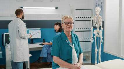 Obraz premium Portrait of old patient attending checkup visit exam with physician, doing consultation to understand physical recovery support. Senior woman waiting on medic to do rehab examination.