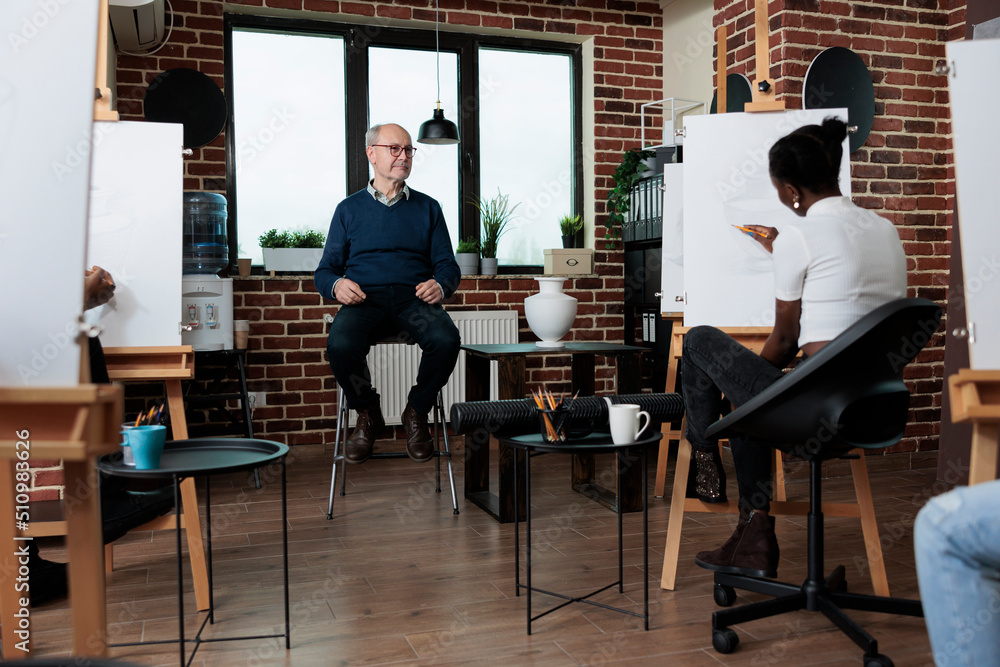 Aufkleber man teacher explaining art technique to diverse team during art course. multi-ethnic people drawing 