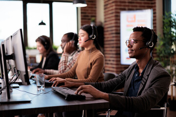 Helpline operator with chronic impairment sitting in wheelchair and working at customer service support. Call center worker with physical disability and health condition helping clients.