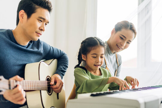 Portrait Of Enjoy Happy Love Asian Family Mother And Little Asian Girl Child Smiling And Having Fun Teaching And Play Piano Music Lesson At Home