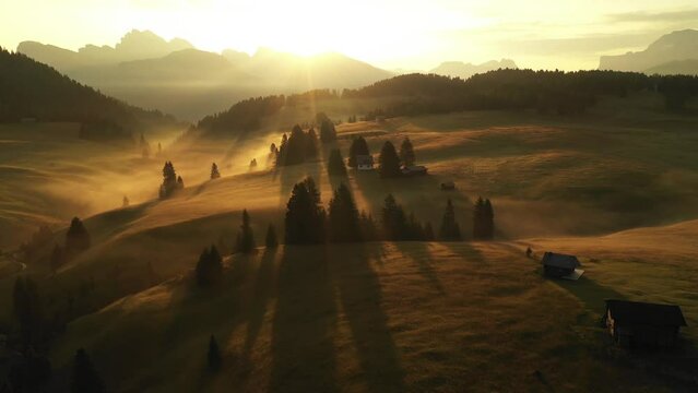 Aerial video of the sunrise in the Dolomites mountains. It was shot on the beautiful meadows of the Seiser Alm plateau with fog and mist in the morning.
