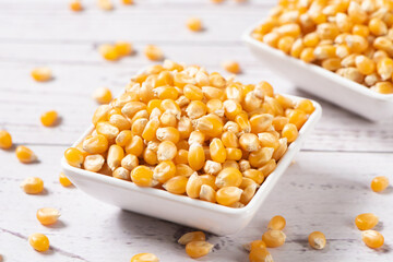 dry corn in small plate on wooden table