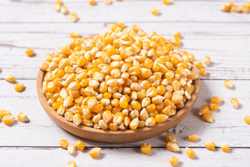 dry corn in plate on wooden table