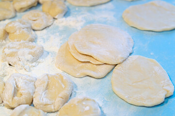 pieces of dough in flour on a blue background
