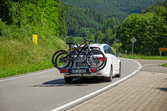Weißer PKW mit Fahrrad-Heckträger von Thule auf einer Landstraße im Dahner Felsenland (Deutschland)